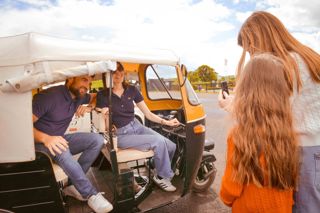 Family Sat In Tuktuk At Outdoor Vehicle Display