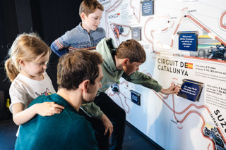 Father And Children Using Race Track Interactive In Williams Racing Exhibition