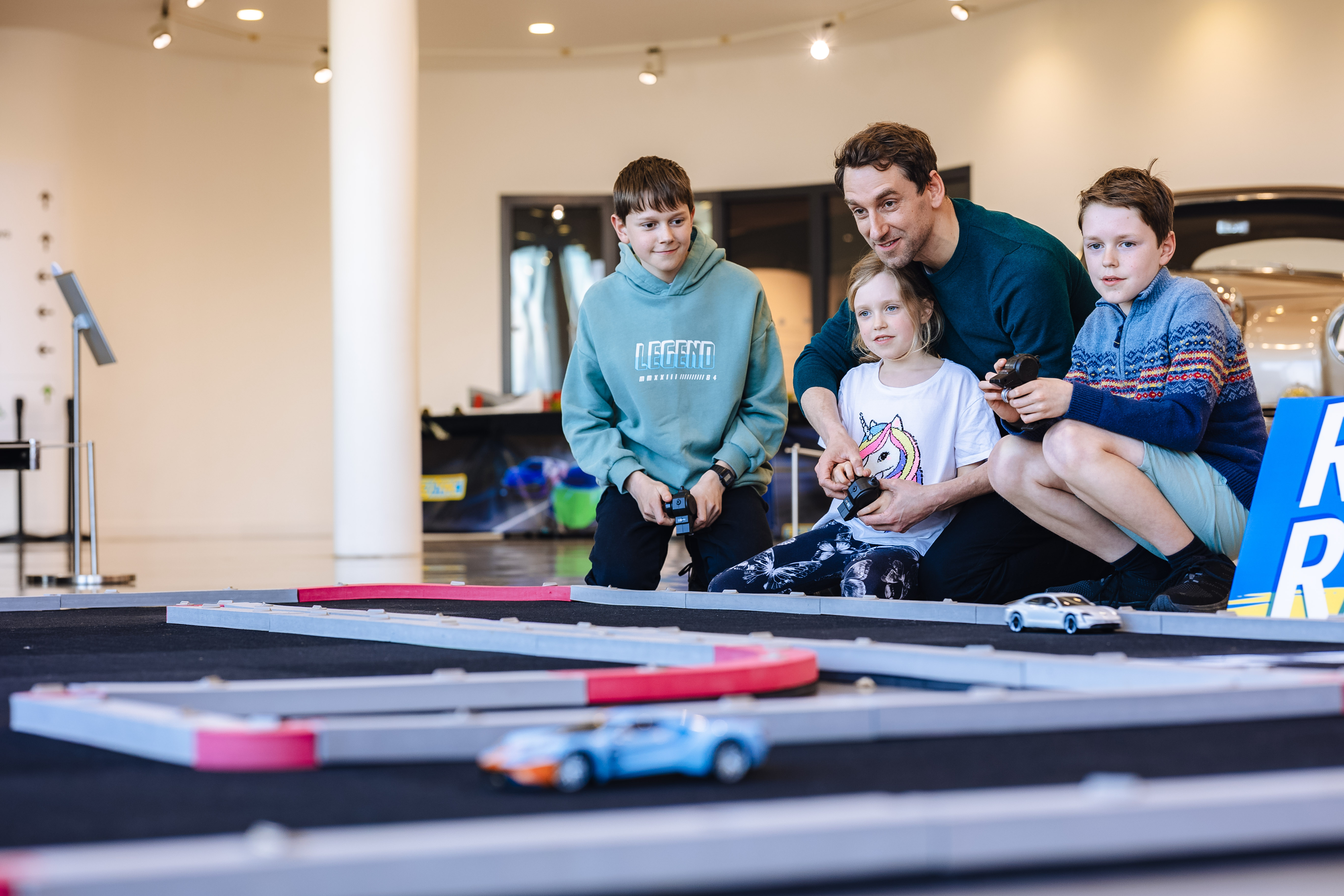Family Playing With Remote Control Cars On Track At Haynes Motor Museum
